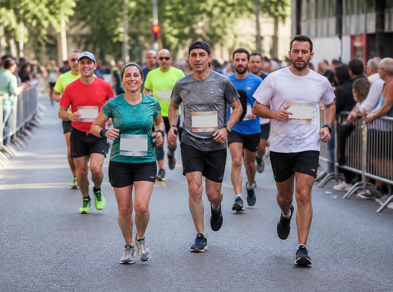 Grupo de participantes corriendo en una carrera popular urbana